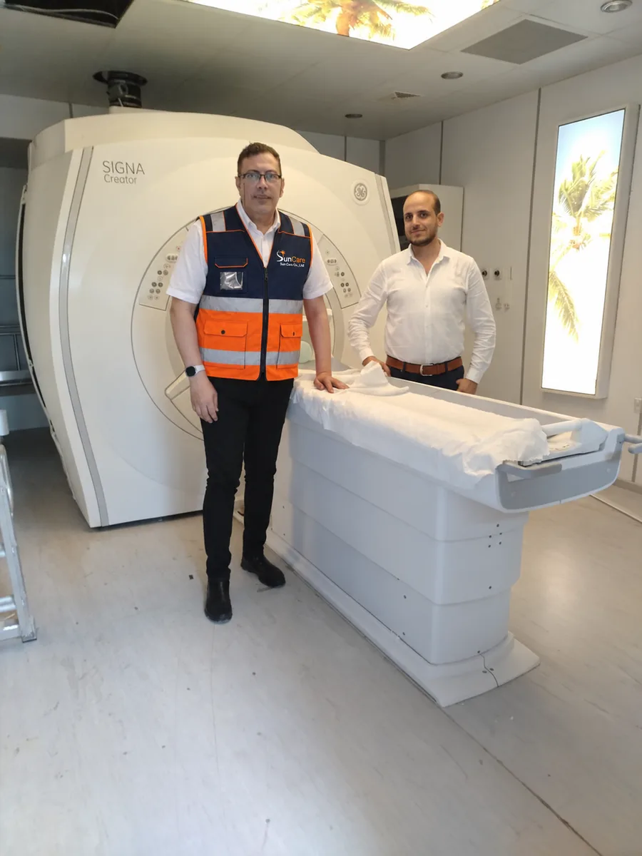 Sun Care engineers beside an MRI patient table
